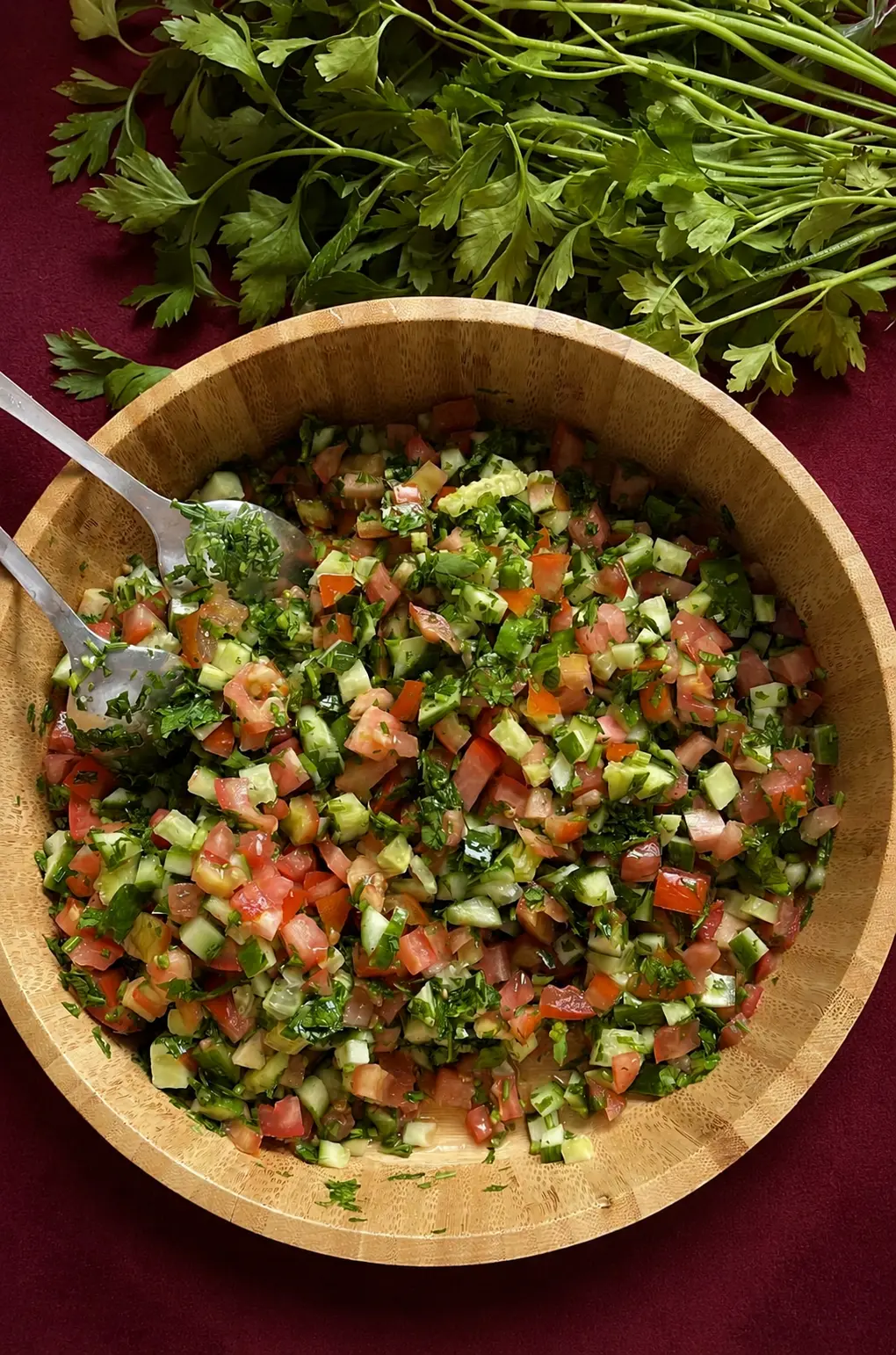 Blandad sallad med tomat, gurka och persilja i träskål